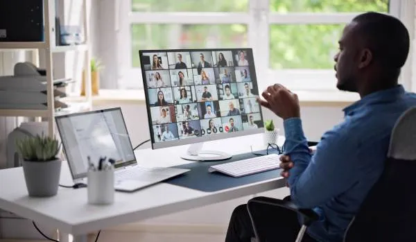 We are looking over a man's shoulder as he participates in a virtual team training.