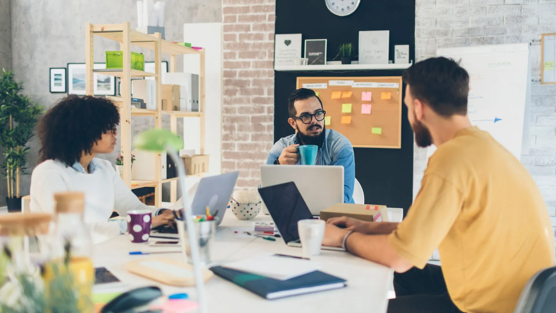 A diverse team is working around a conference table.