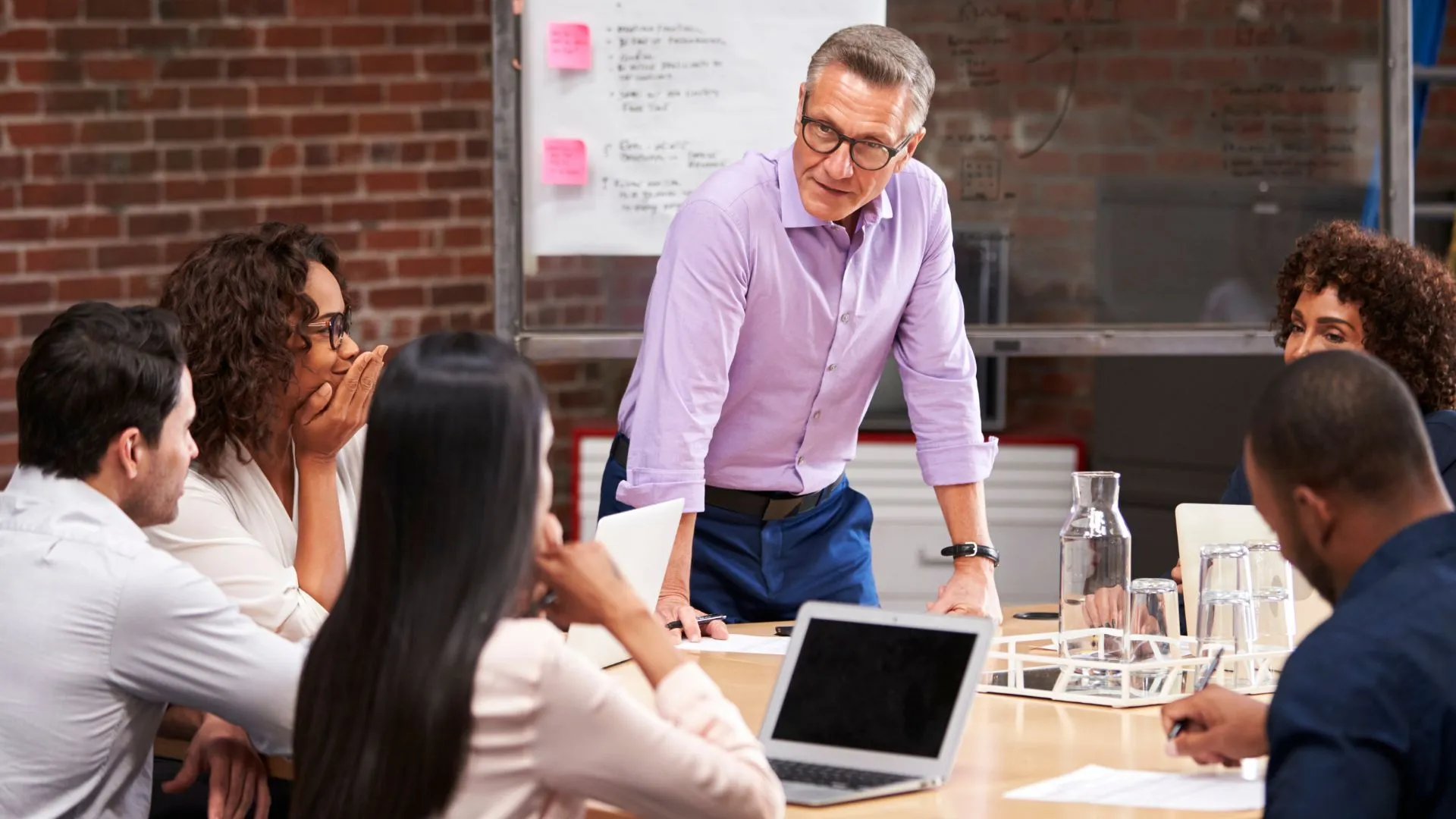 A man is leading a small group discussion in a professional development program.