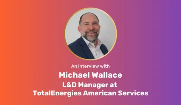 A centered, circular photo of Michael Wallace on an orange-purple gradient rectangle with white bold text underneath: "An interview with Michael Wallace L&D Manager at TotalEnergies American Services"