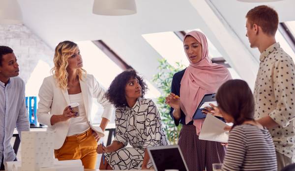 A diverse team of people are planning their annual workplace holiday activities.