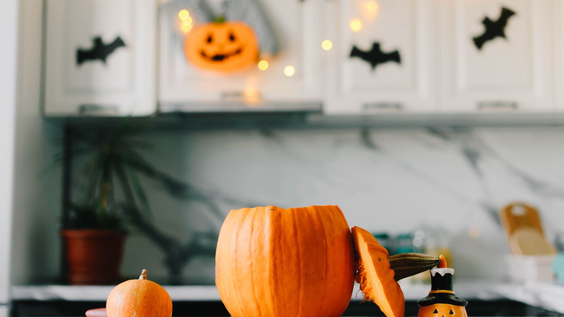 A Jack-o-lantern sits on the counter of an office break room that is decorated for Halloween.