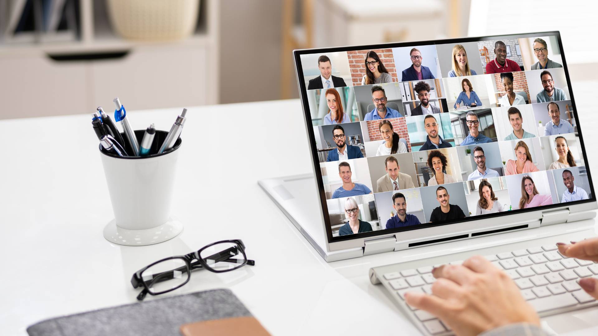 We're looking over someone's shoulder at a virtual all-hands meeting on their laptop.