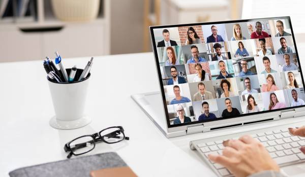 We're looking over someone's shoulder at a virtual all-hands meeting on their laptop.