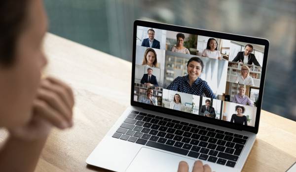 We are looking over the shoulder of someone at their laptop screen where they are participating in a live training with peersl