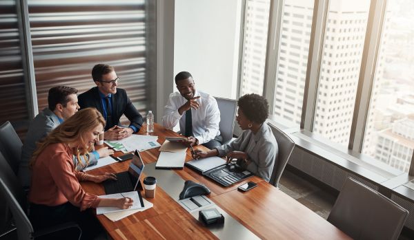 A diverse People team is gathered around a conference table doing strategic planning.