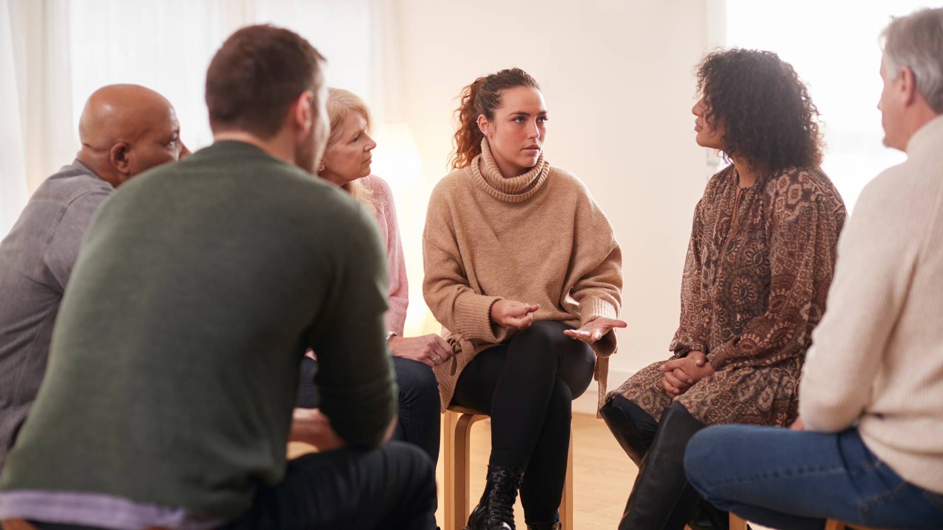 A group of people are sitting in a circle, talking and sharing.