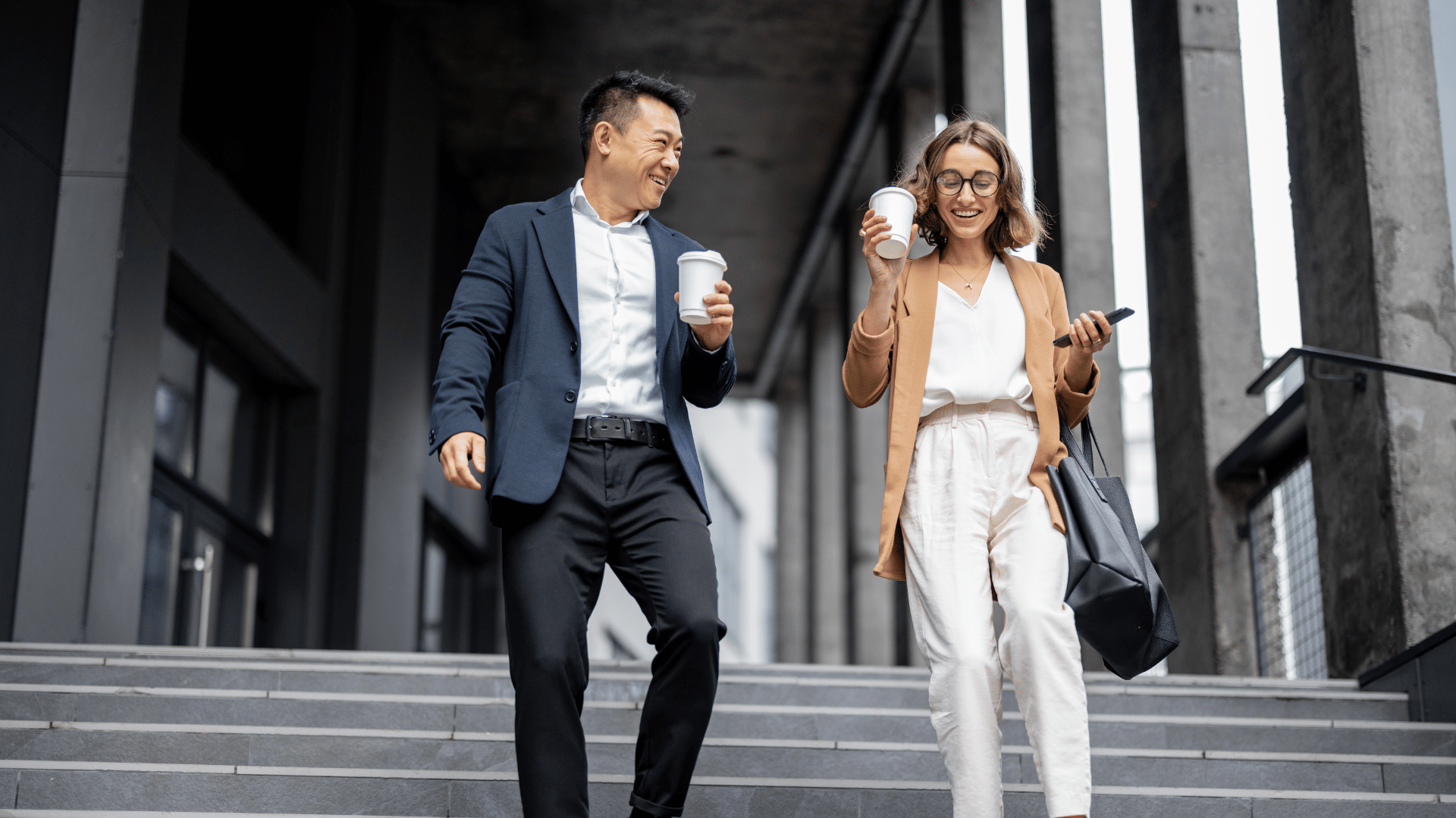 Two business people walking and talking in a city.
