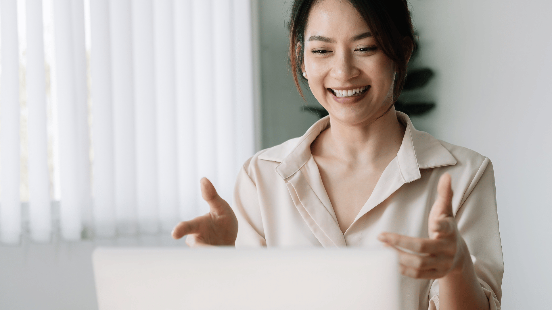 Asian woman presenting during a virtual meeting.