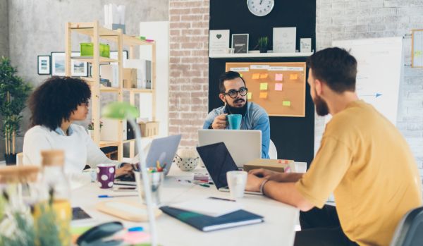 A diverse team is working around a conference table.