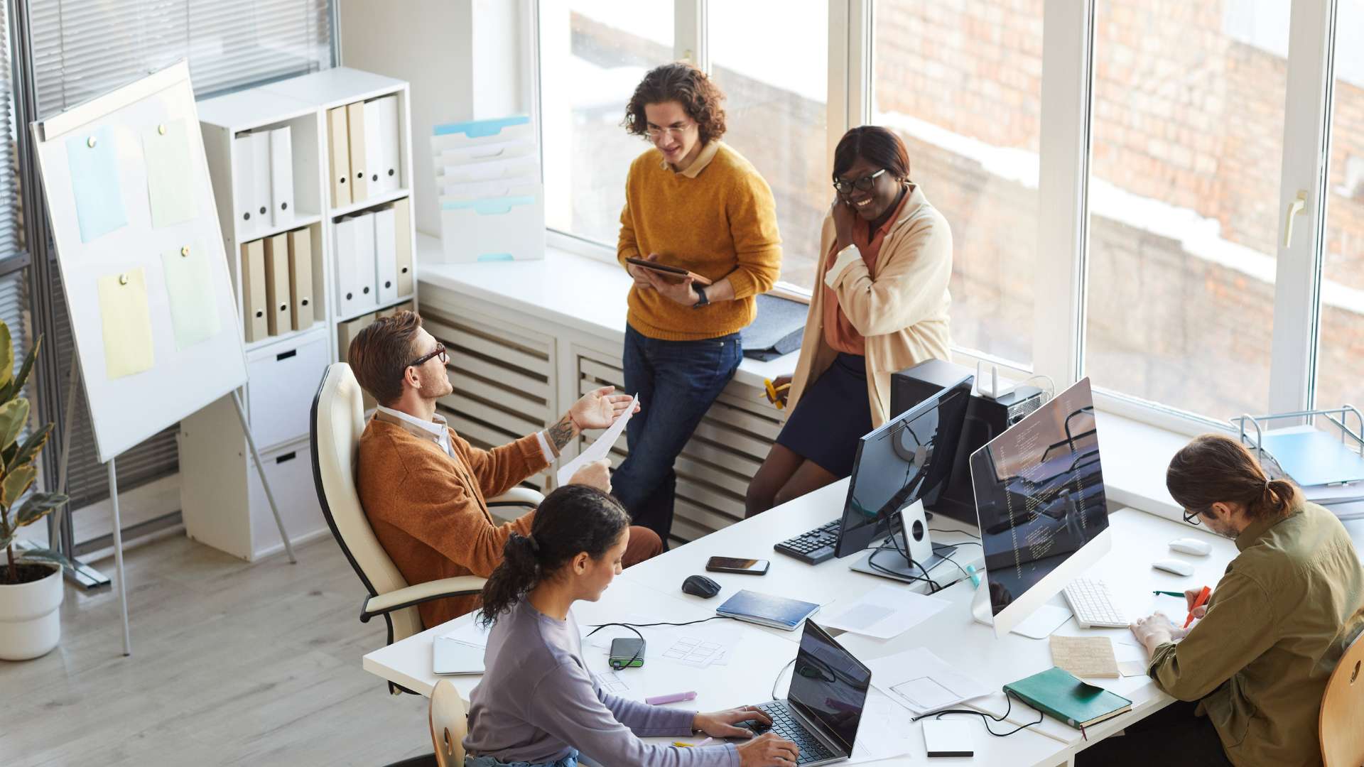 A diverse team works together in a bright, open office space