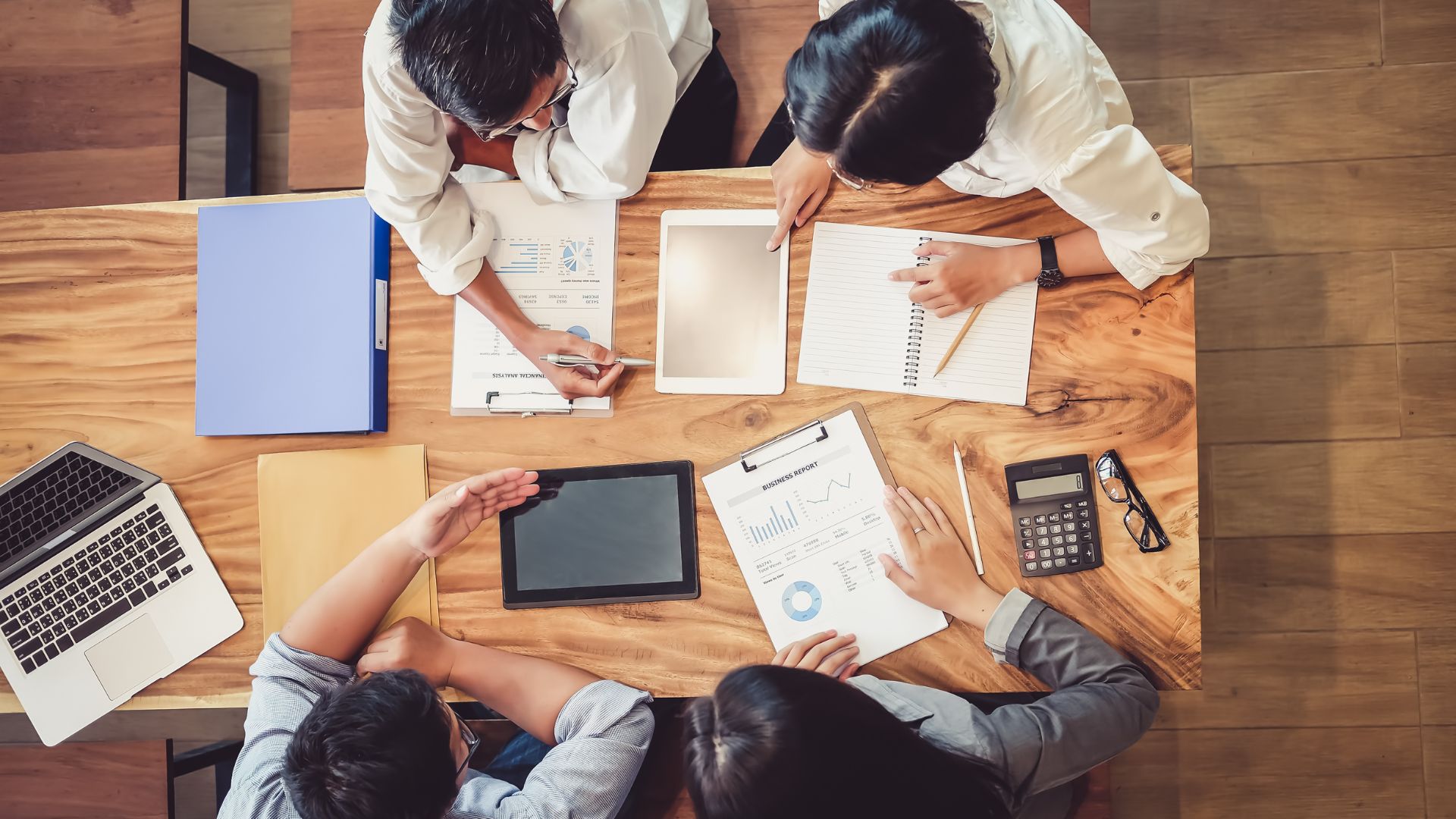 We're looking down at a group of people reviewing budgets at a conference table.