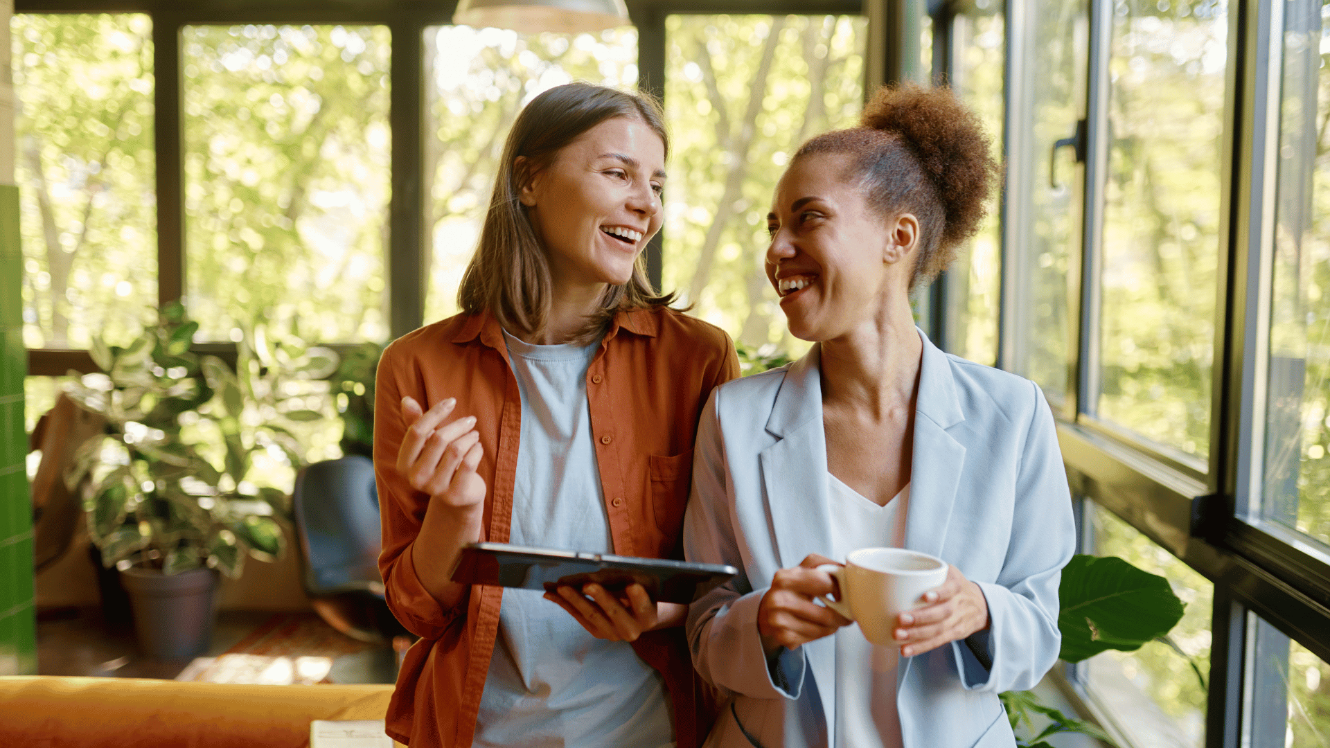 Two happy coworkers chatting at work.