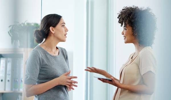 Two women are having an open and happy conversation.