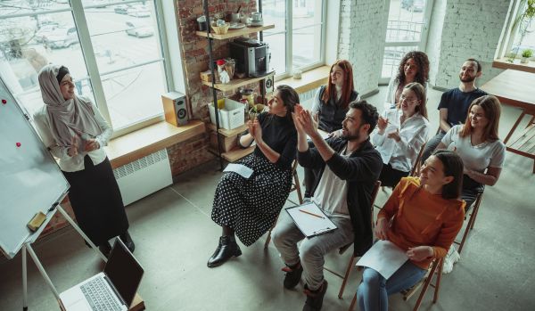 A diverse group of people are participating in high-performance culture training.