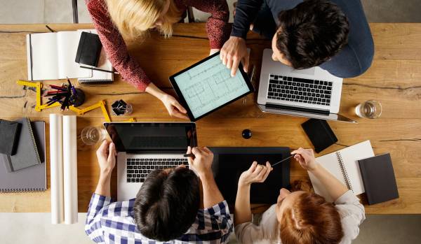 An overhead shot of a team collaborating on a project around a conference table.