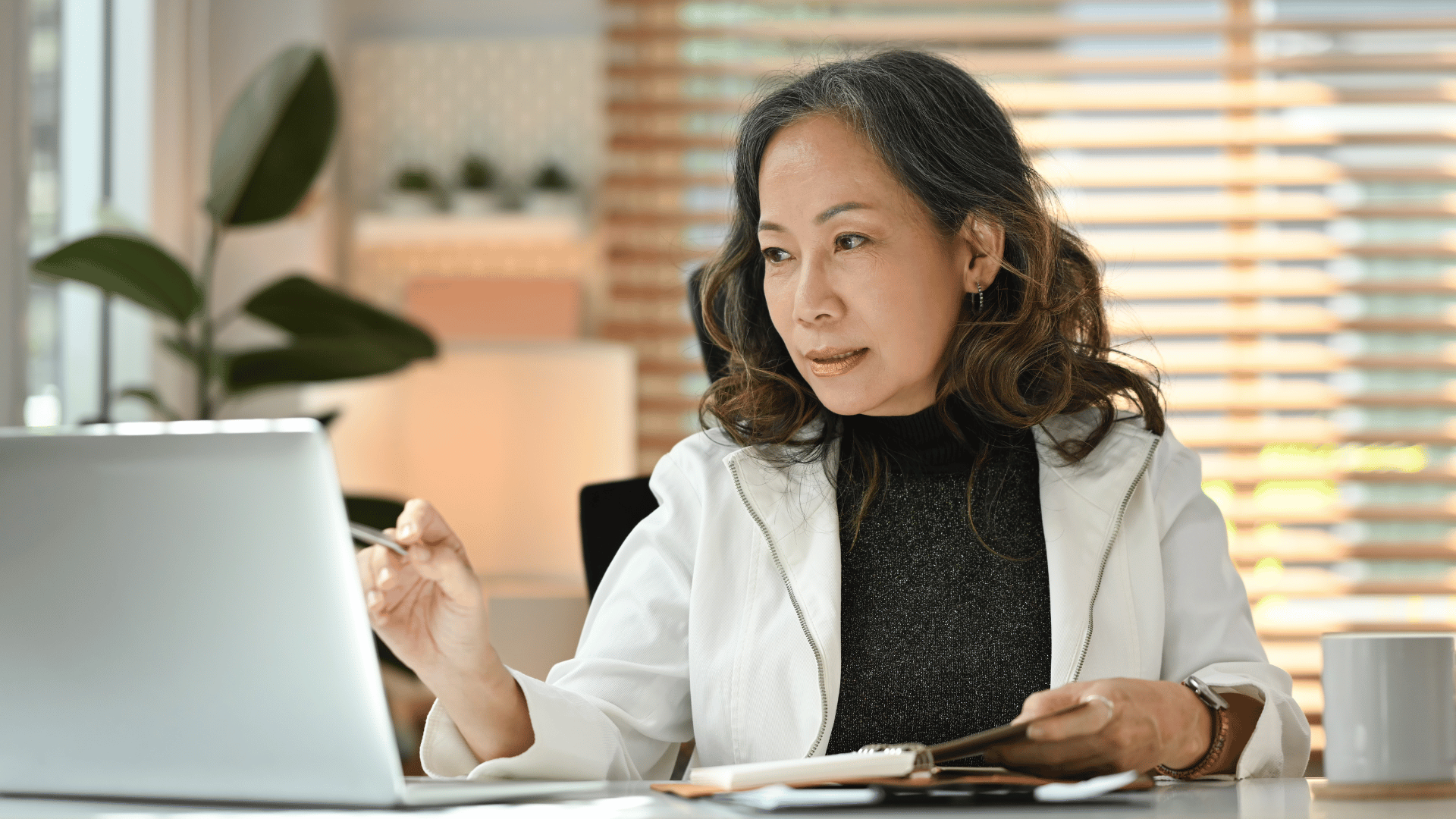 An elegant, mature woman working by herself from home.