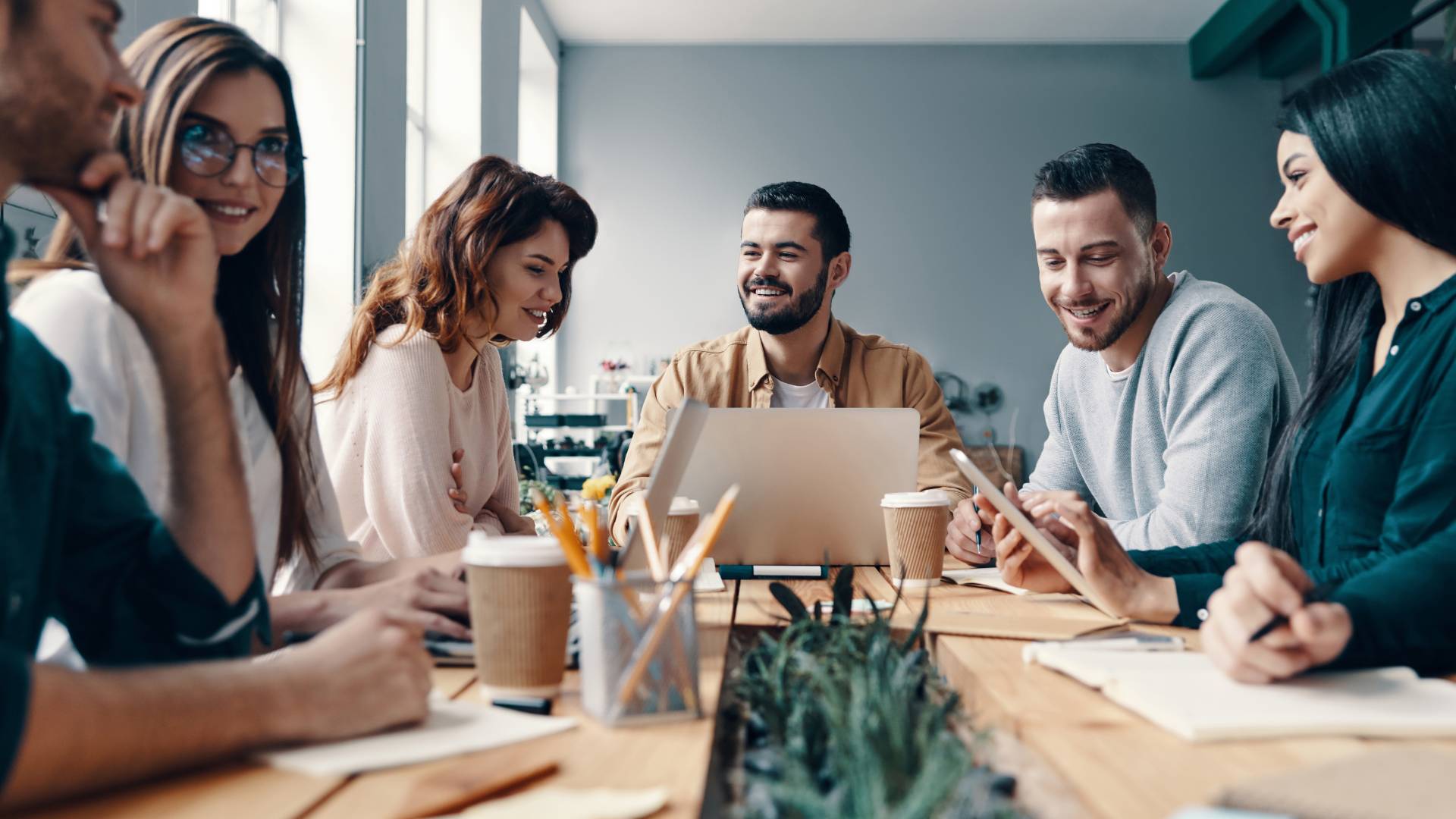 A diverse team is working around a conference table.