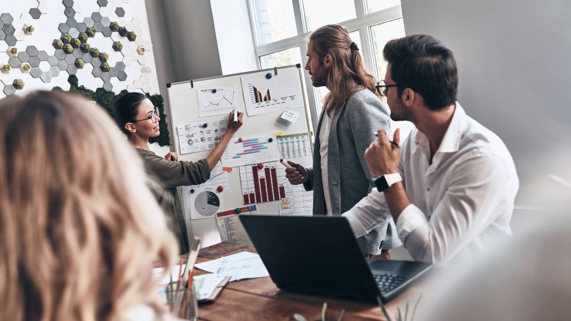 A team is working together on a project in a conference room on a flipchart.