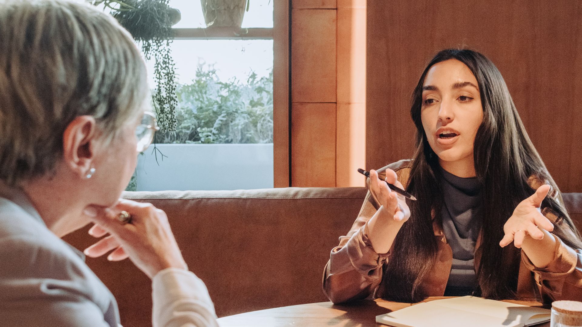 A two-person HR team is planning at a table in a common space.