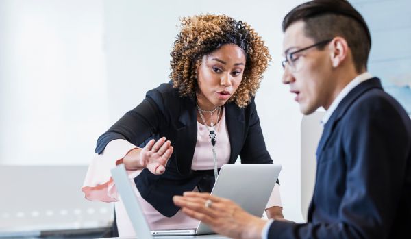 Two people are discussing business priorities in their office.