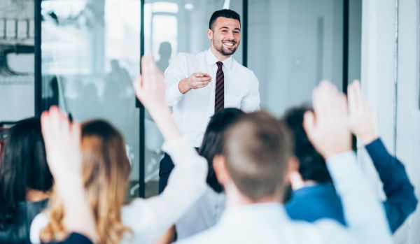 A man is leading a training program in an office.