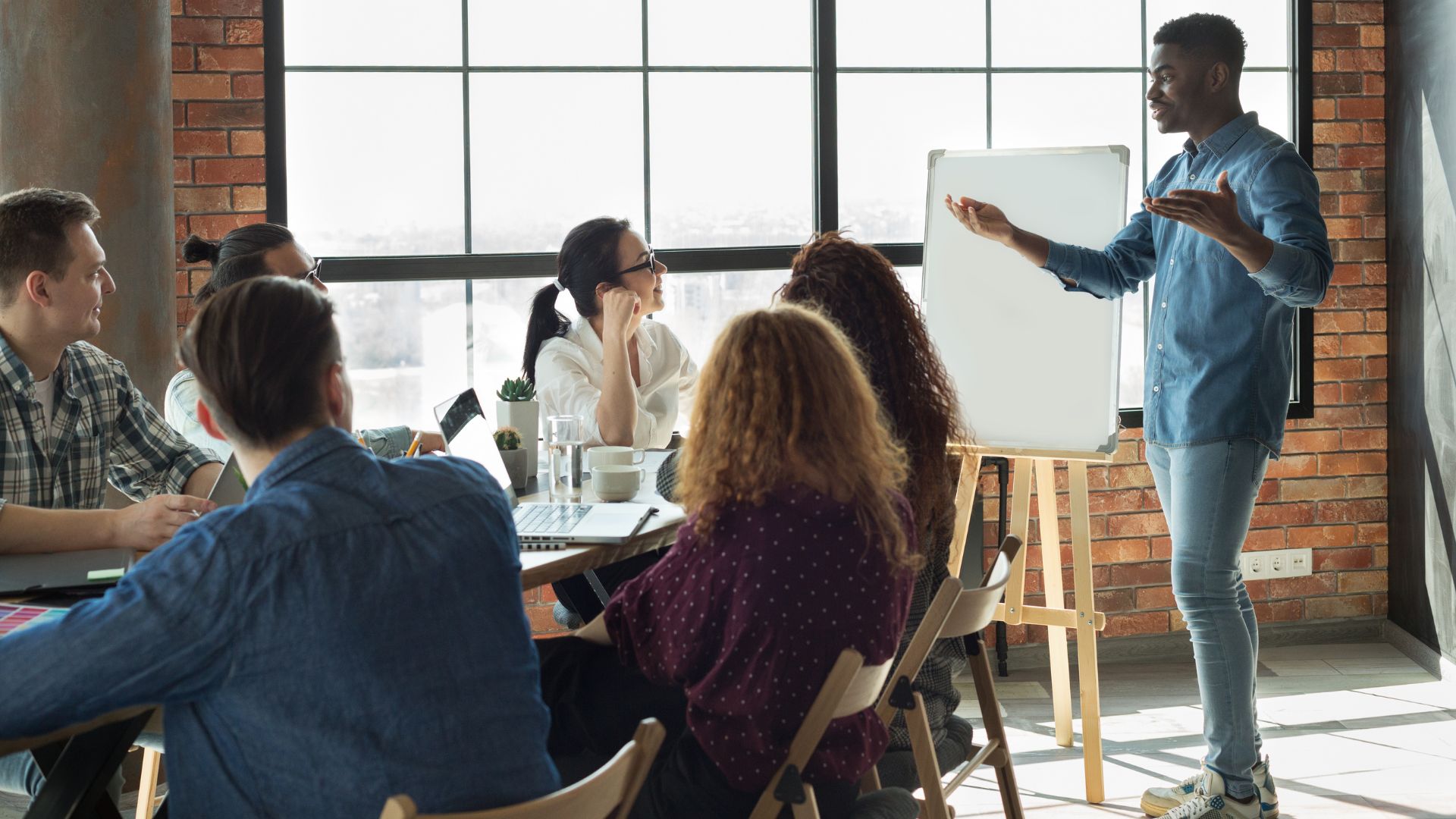 A man stands at the front of a room leading a professional development program.