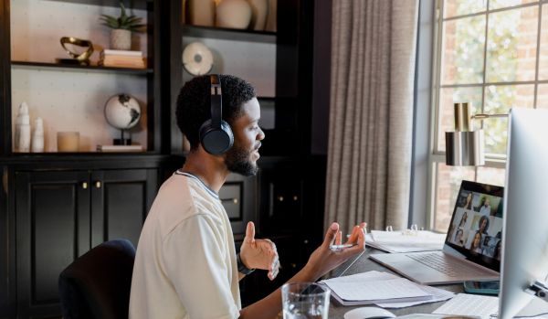 A young man is introducing himself on a virtual meeting.