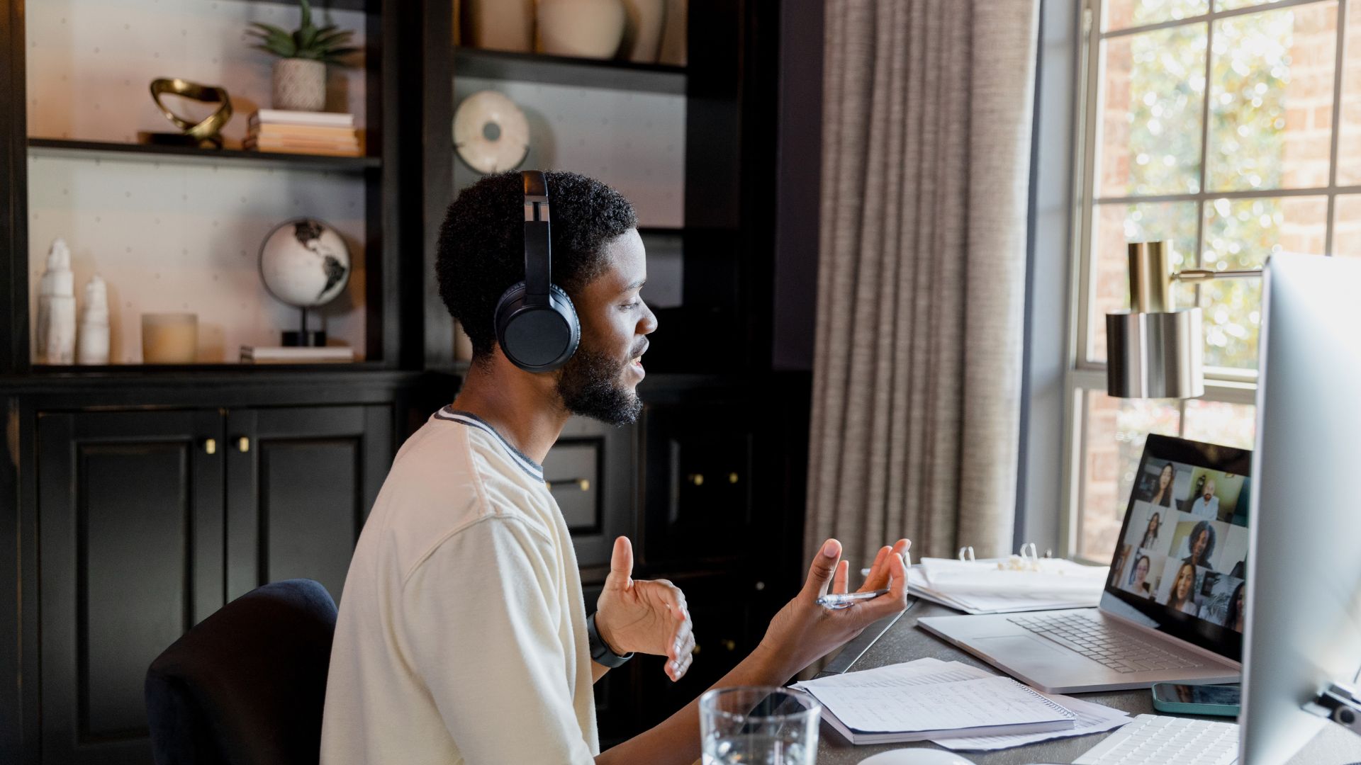 A young man is introducing himself on a virtual meeting.