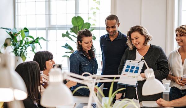 There are six people in an office conference room participating in a training for professional growth.