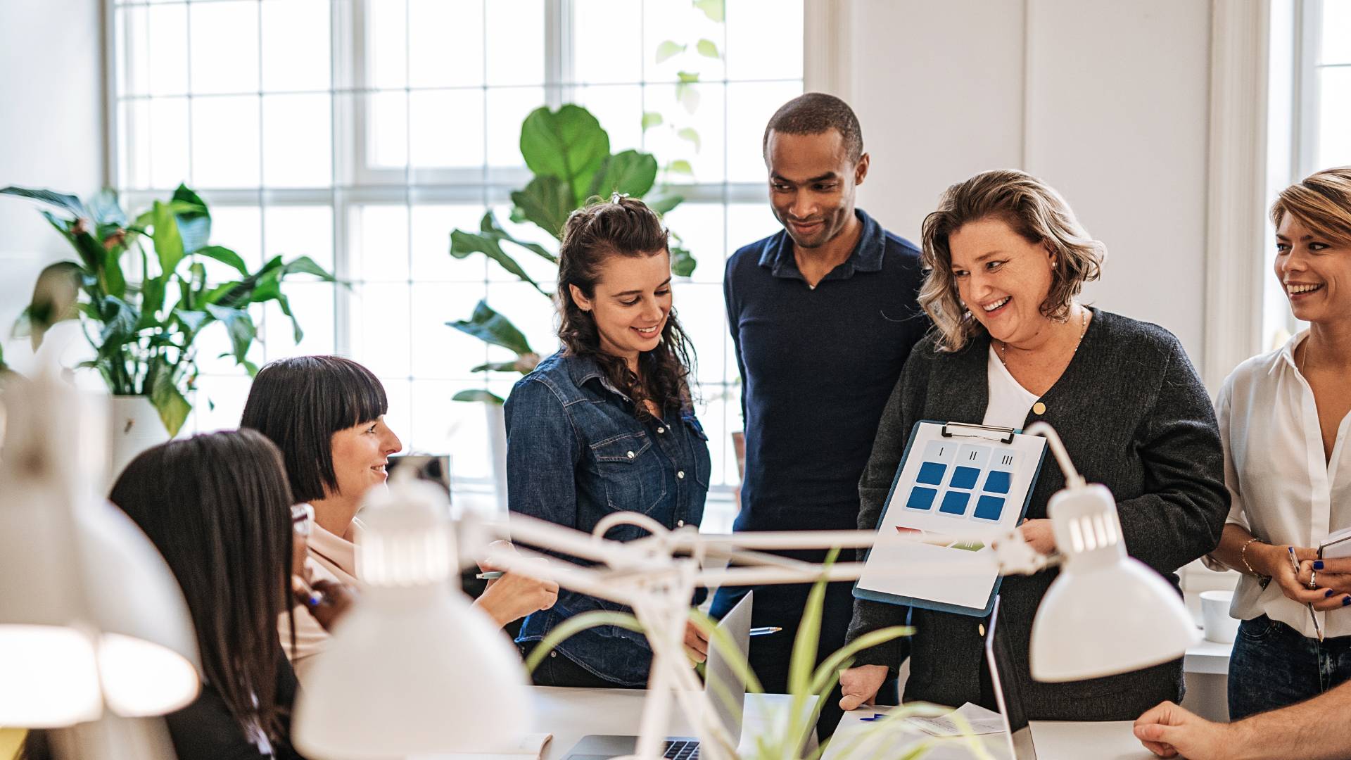There are six people in an office conference room participating in a training for professional growth.