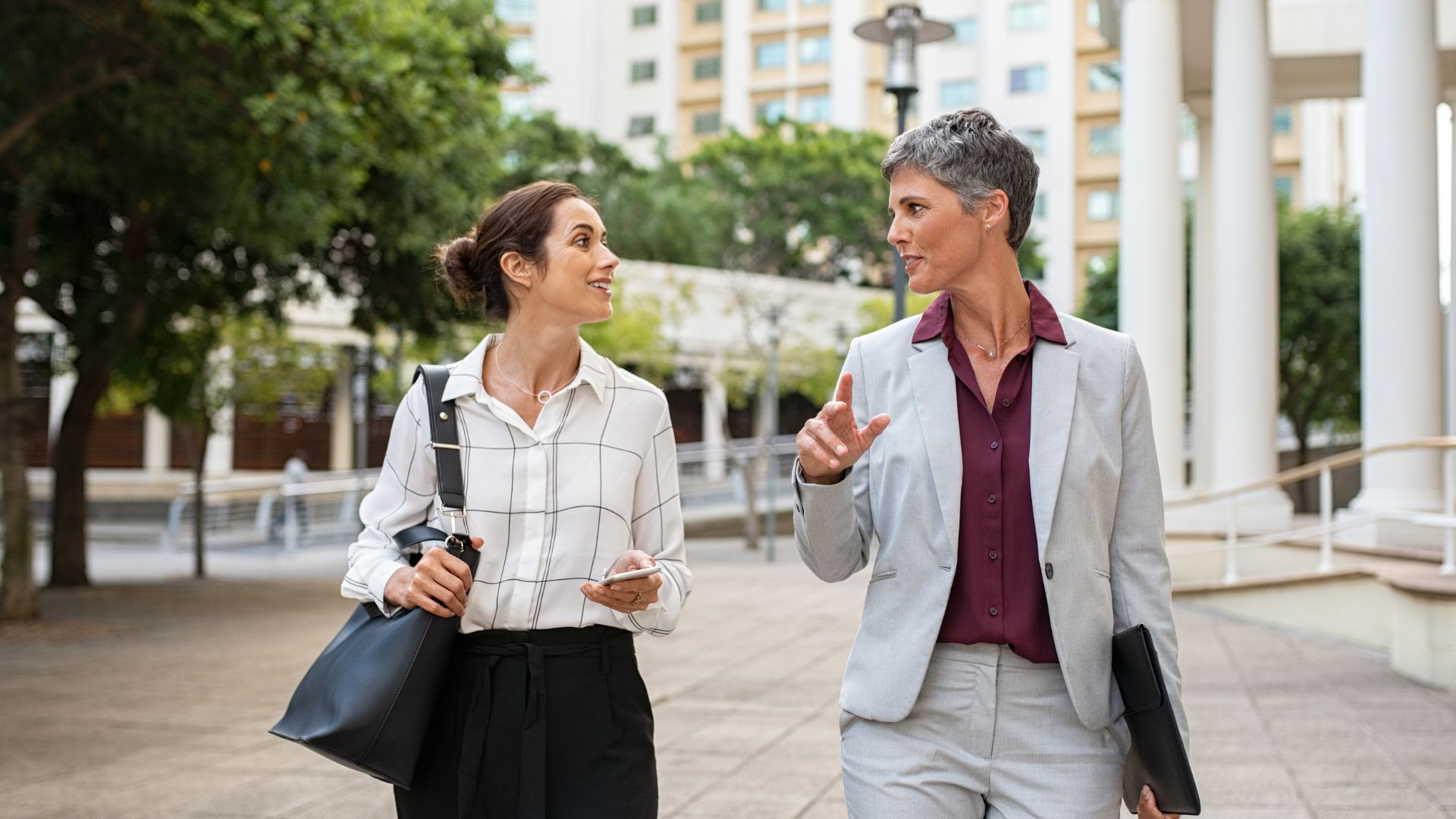 A manager and her employee are walking outside having a coaching conversation.