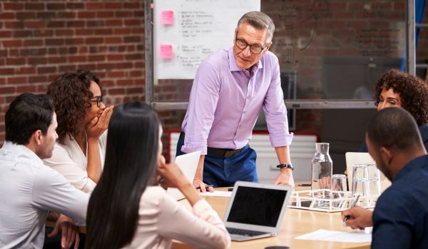 A man is leading a small group discussion in a professional development program.