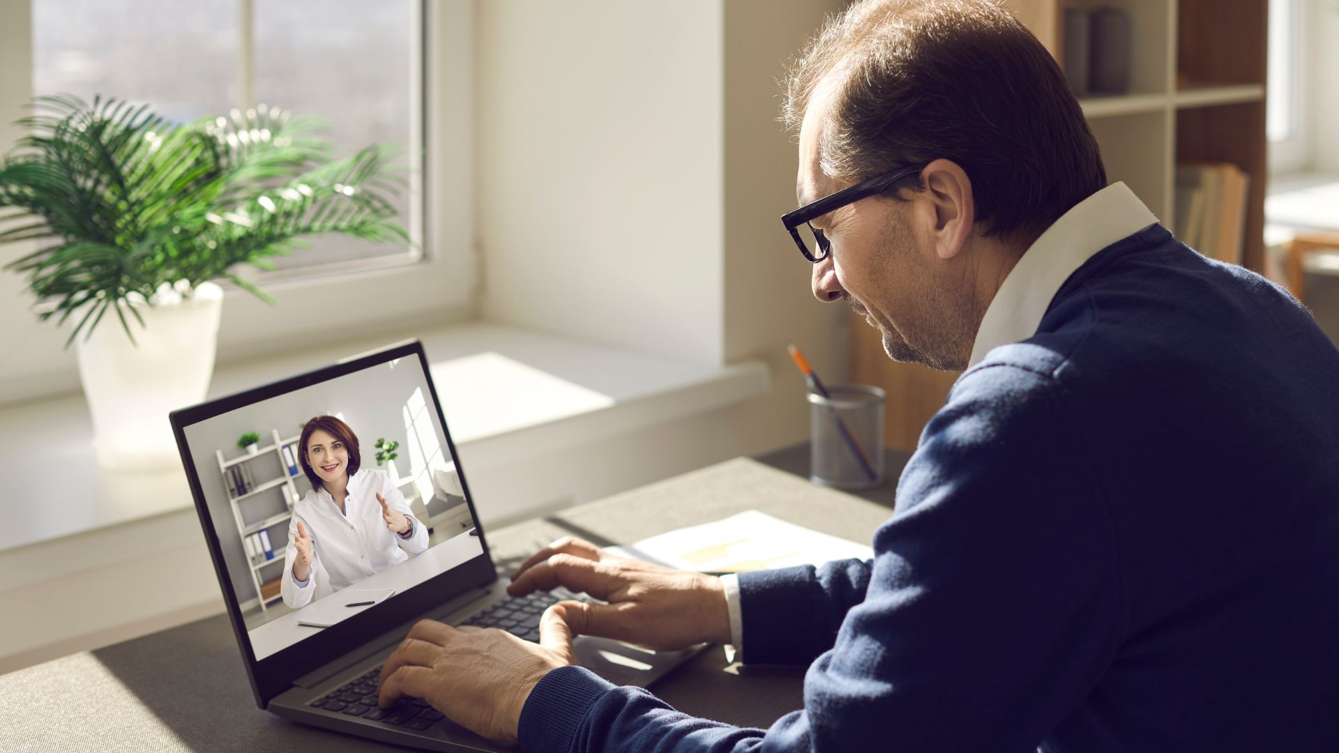 A man is conducting a performance review virtually on his laptop.