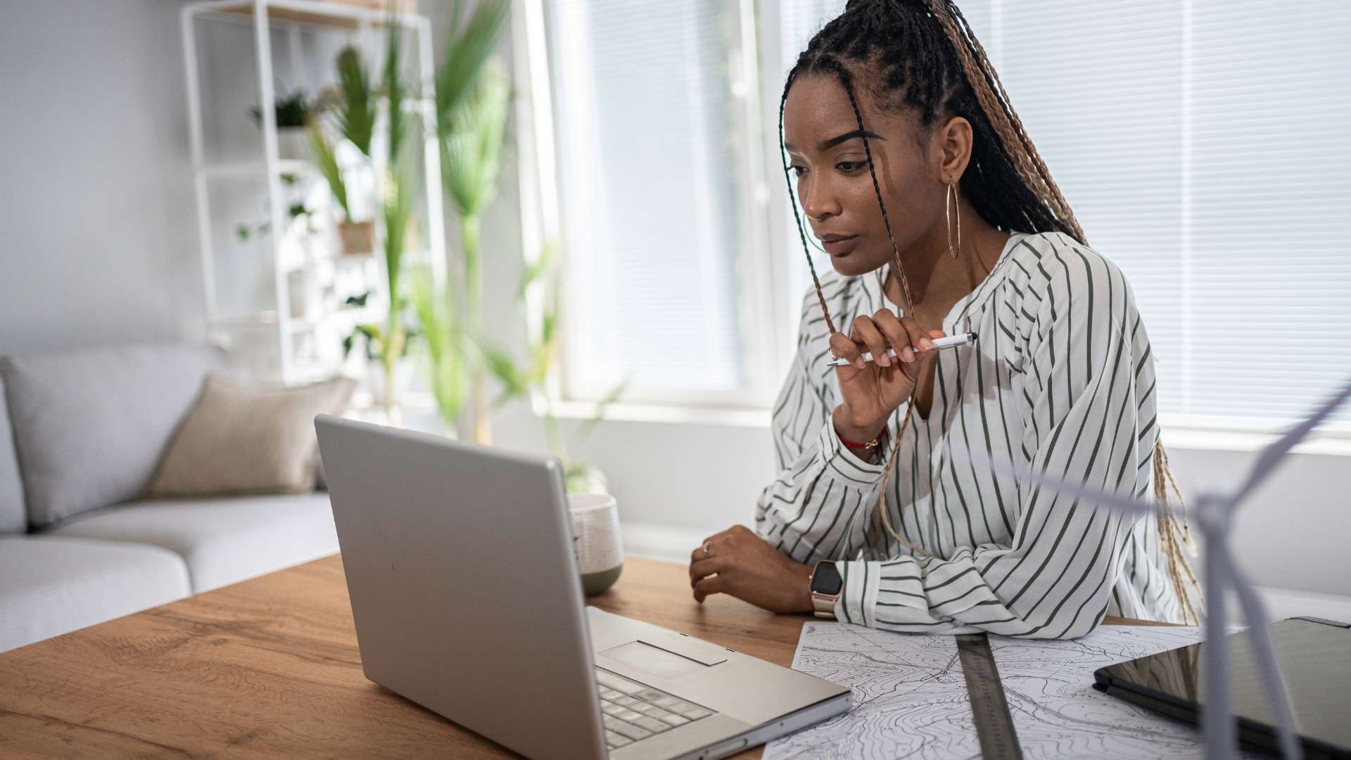Gen Z woman works on her laptop in her home office.