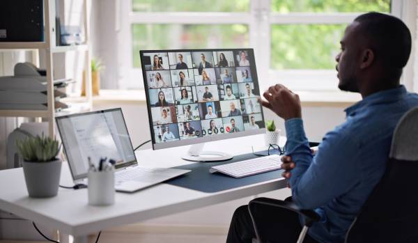 We are looking over a man's shoulder as he participates in a virtual team training.