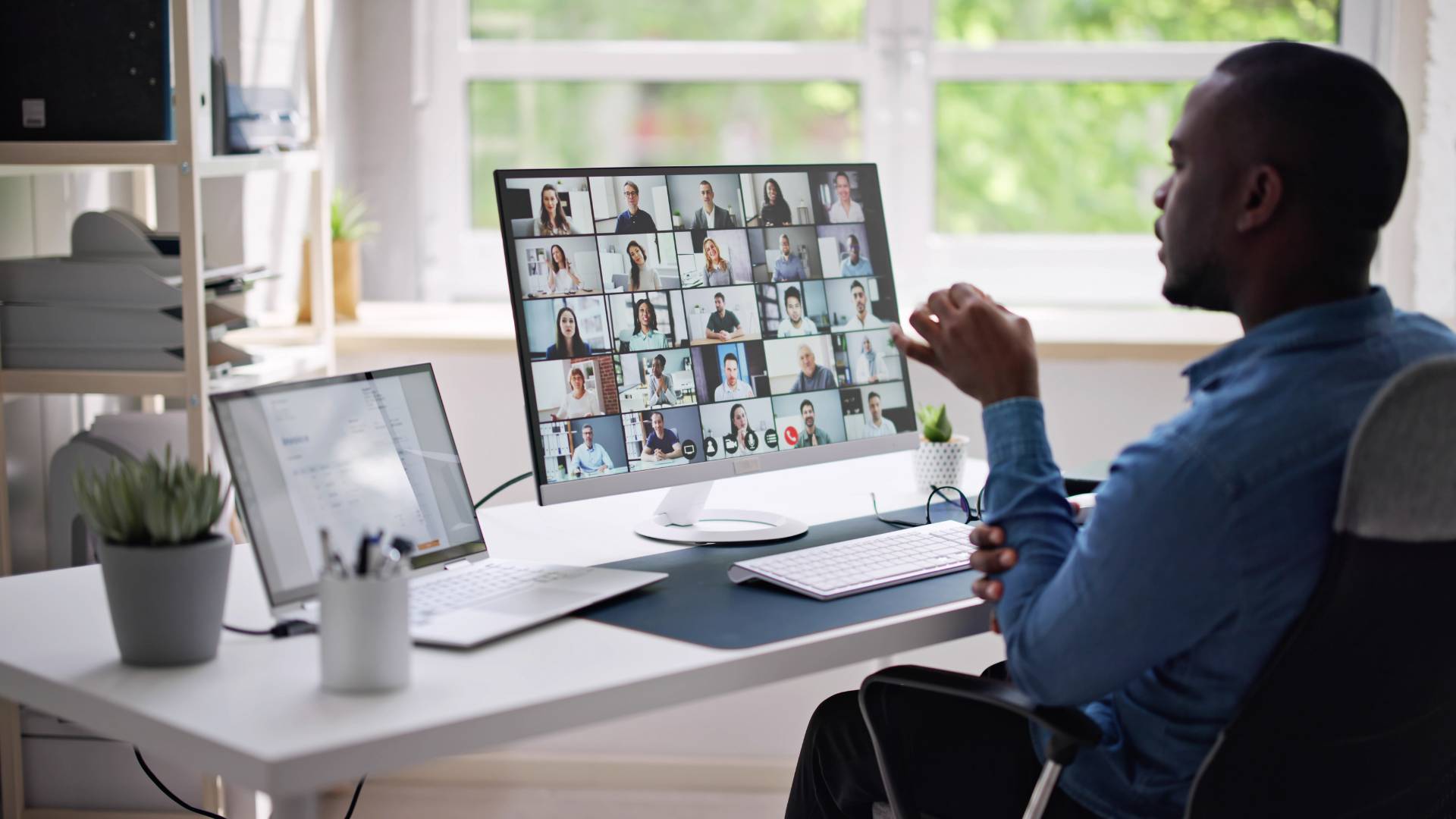 We are looking over a man's shoulder as he participates in a virtual team training.