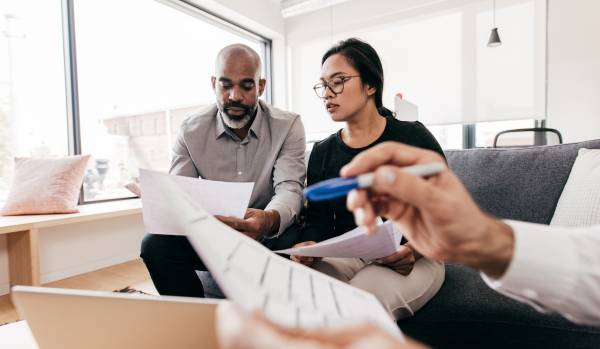 A man and woman sitting on a couch in an office going over a career development plan.