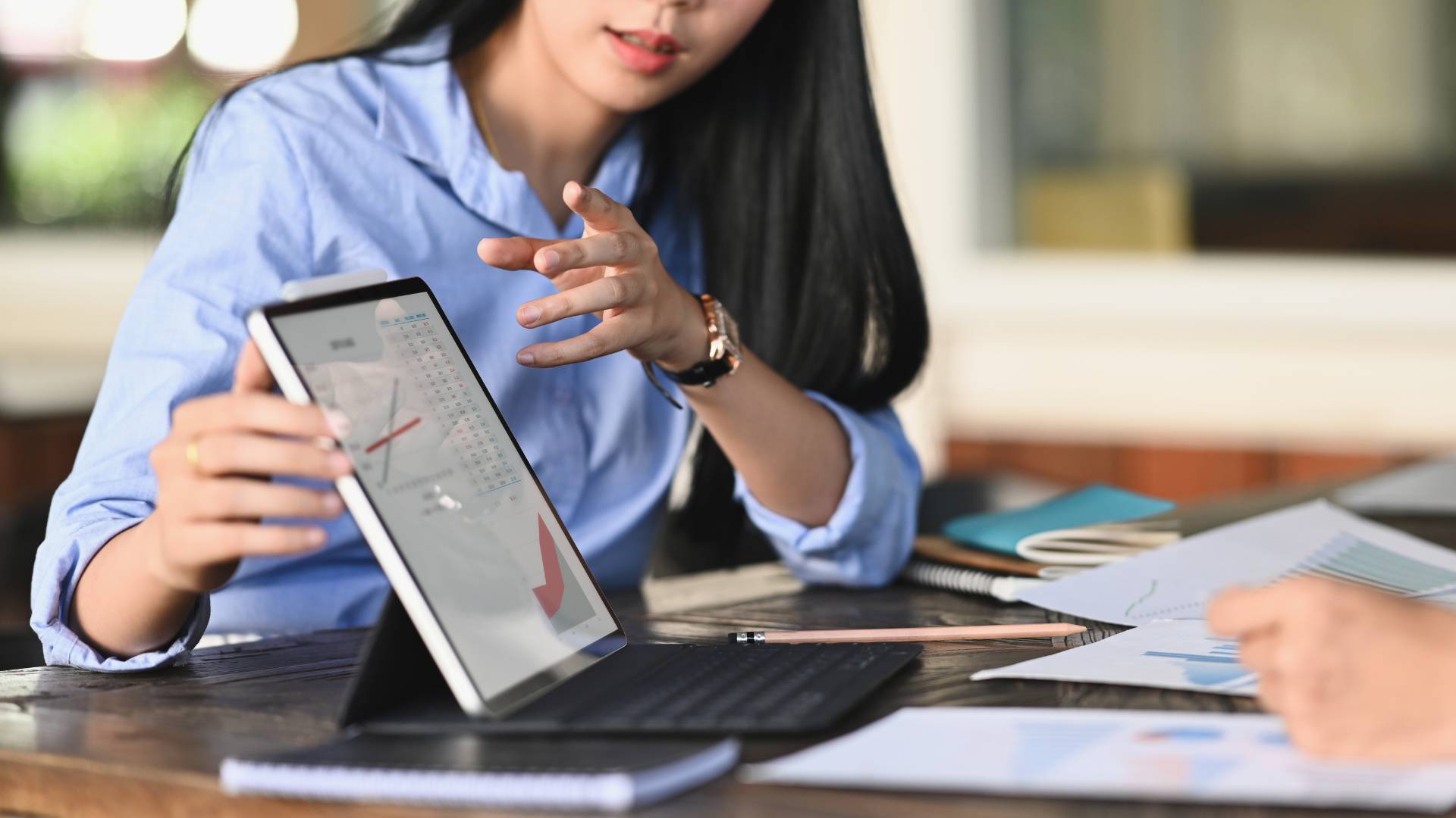 A woman is presenting some data on an tablet to a colleague.
