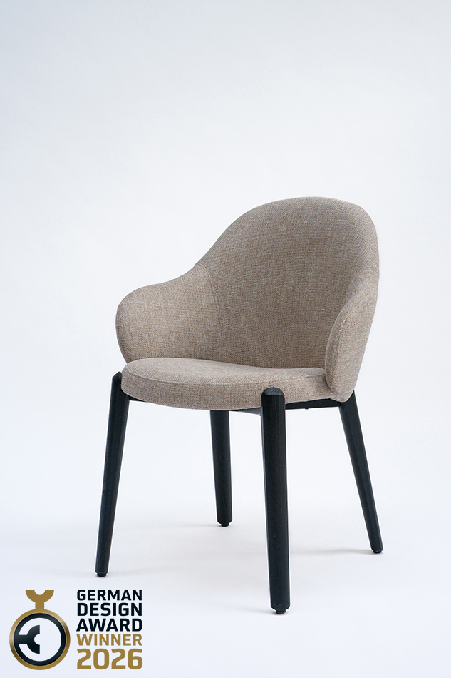 Ein Stuhl Cleo ohne Armlehnen von formstelle für May mit Füßen aus Holz und Stoffpolster von schräg vorne in sehr dunkler Atmosphäre.