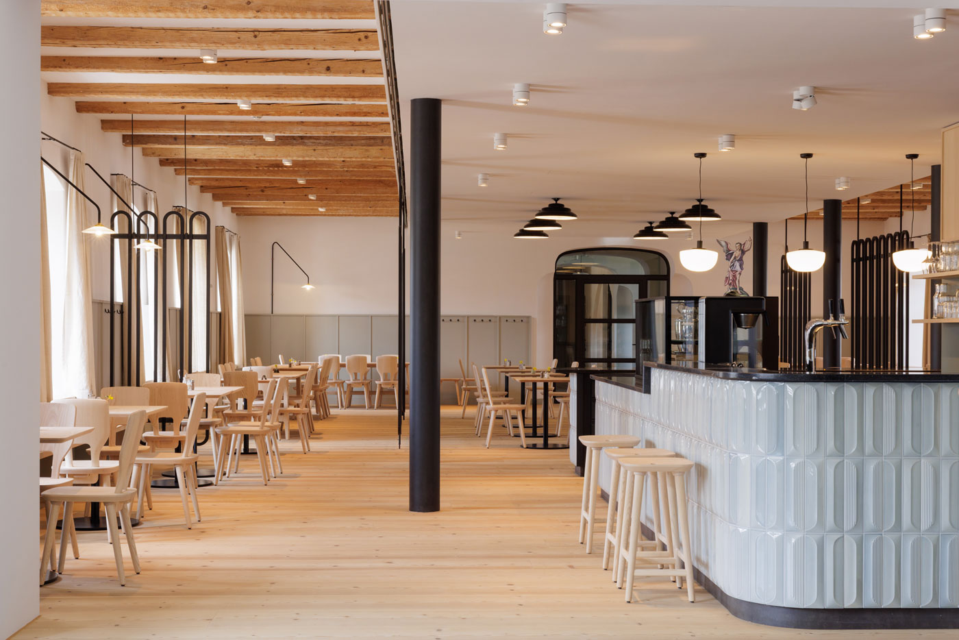Perspektivansicht des Cafés im Erdgeschoss des Josephstrakts des Klosters Beuerberg mit gefliestem Bartresen, Kücheneinbau mit Stauraum und Bistrotischen, von formstelle gestaltet.