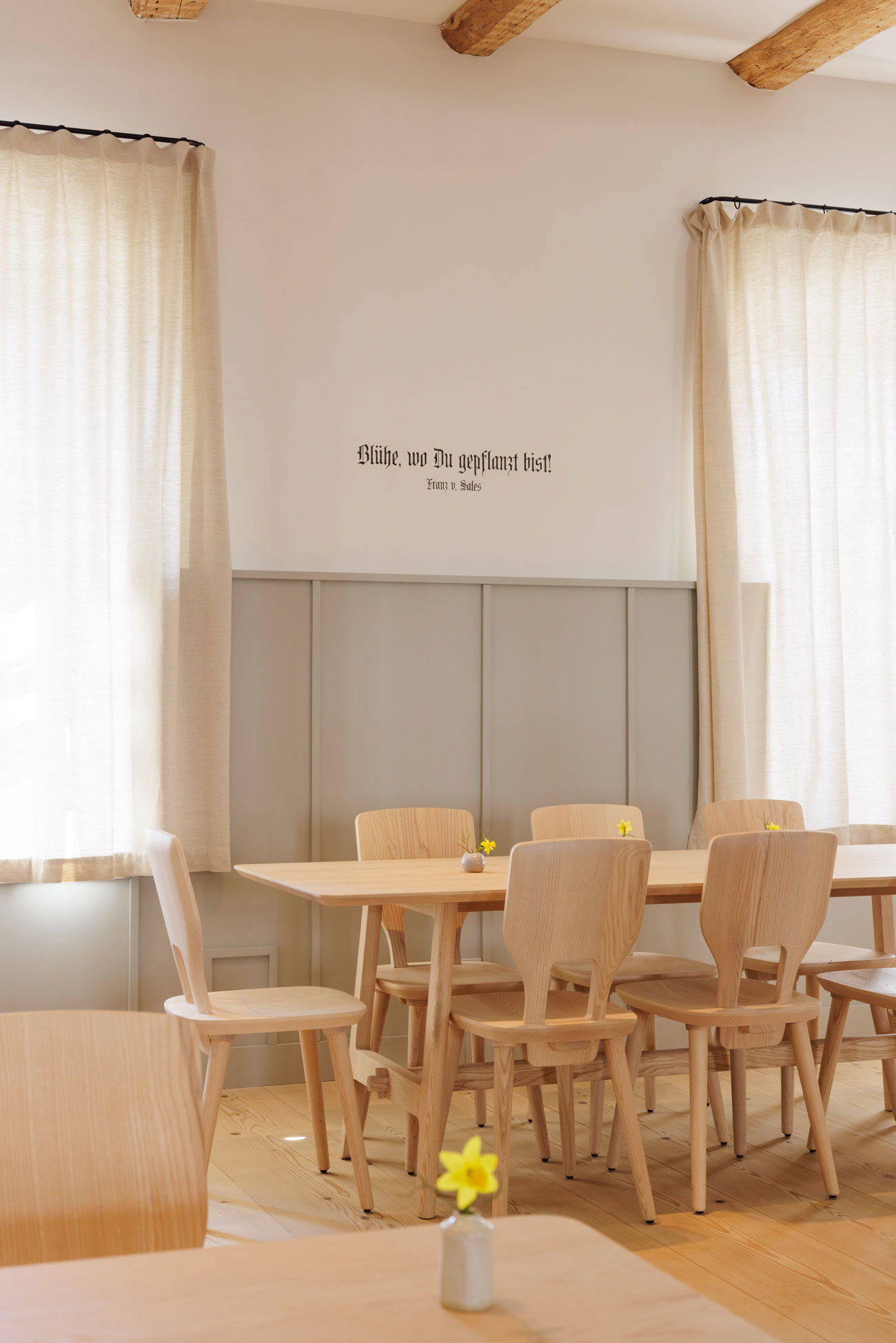 Perspektivansicht des Cafés im Erdgeschoss des Josephstrakts des Klosters Beuerberg mit gefliestem Bartresen, Kücheneinbau mit Stauraum und Bistrotischen, von formstelle gestaltet.