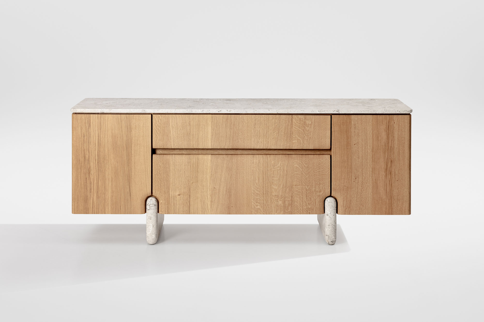Frontansicht des Sideboards Onde von formstelle für Zeitraum in Eiche mit Steinfüßen und Marmor Platte vor hellem Hintergrund.