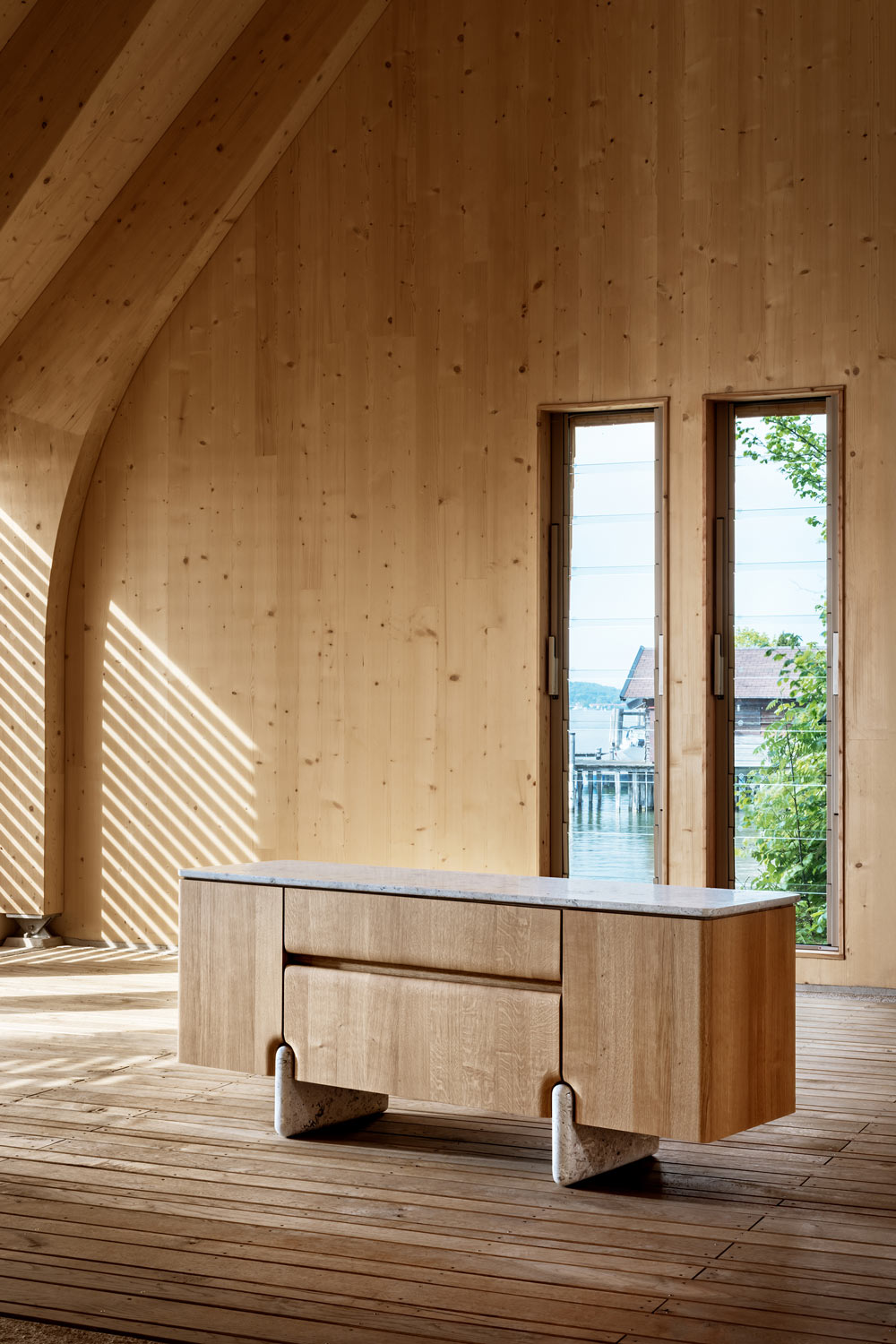 Schräge Frontansicht des Sideboards Onde von formstelle für Zeitraum in Eiche mit Steinfüßen in Bootshaus am See.