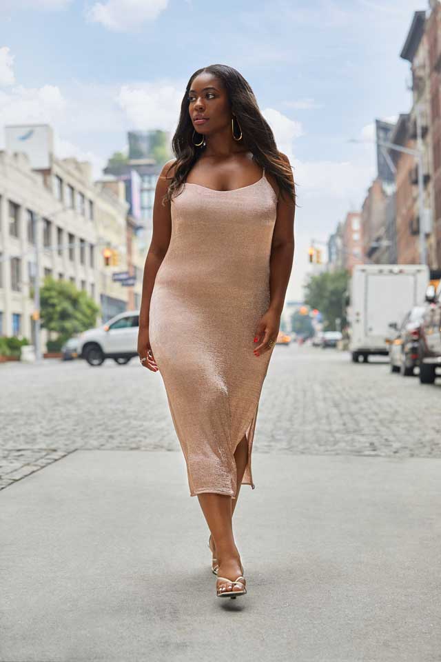 Model wearing a rose gold midi bodycon dress on a cobblestone street. Image by Plural, NYC - Social Media Marketing & Content.