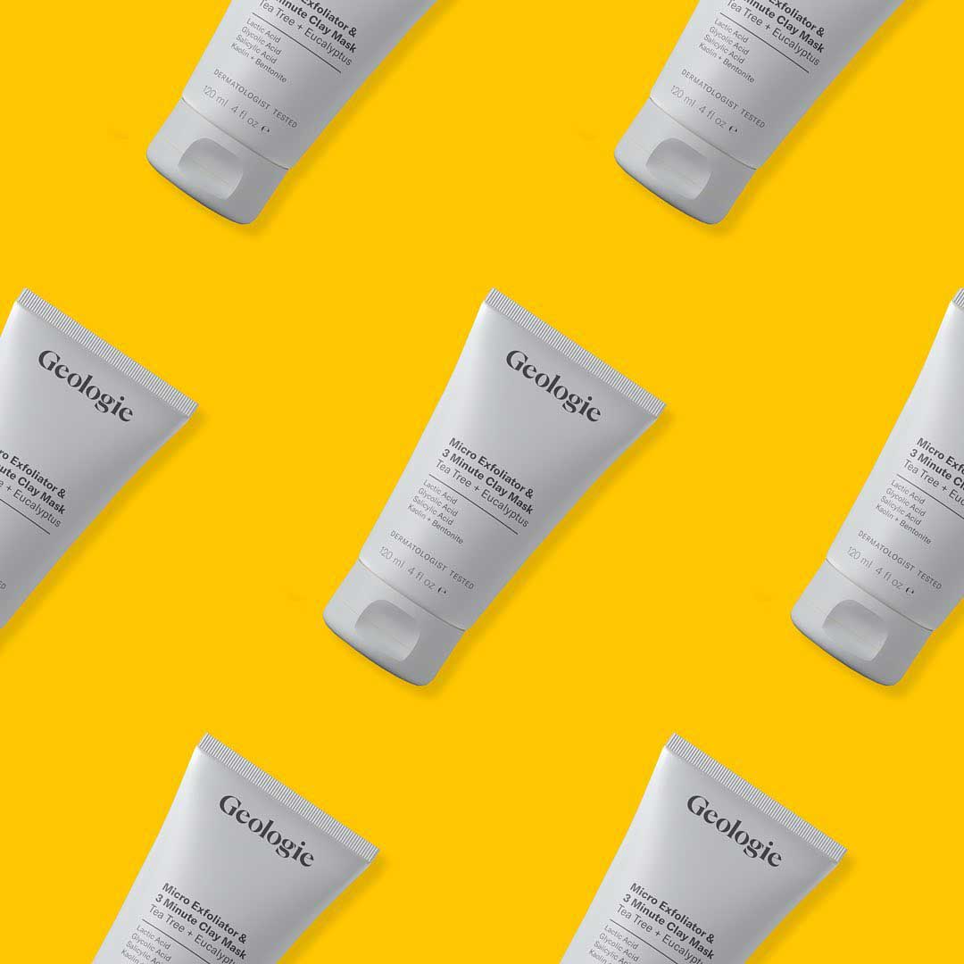 Multiple Geologie exfoliator mask bottles on a yellow background.  Image courtesy of Plural, NYC - Social Media Marketing and Content Production Studio.