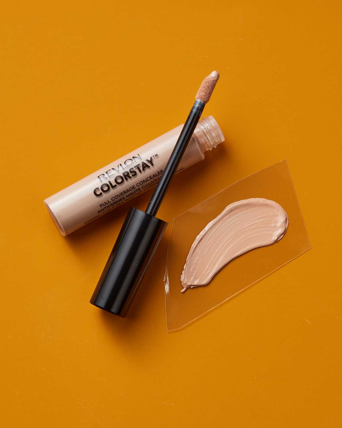 Revlon ColorStay Full Coverage Concealer tube and applicator with a swatch of concealer. Image courtesy of Plural, NYC - Social Media Marketing and Content Production Studio.