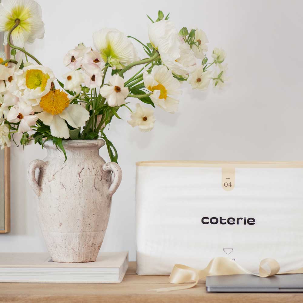 Woman in beige outfit holding baby in the air. Image from Plural, NYC - Social Media Marketing & Content.