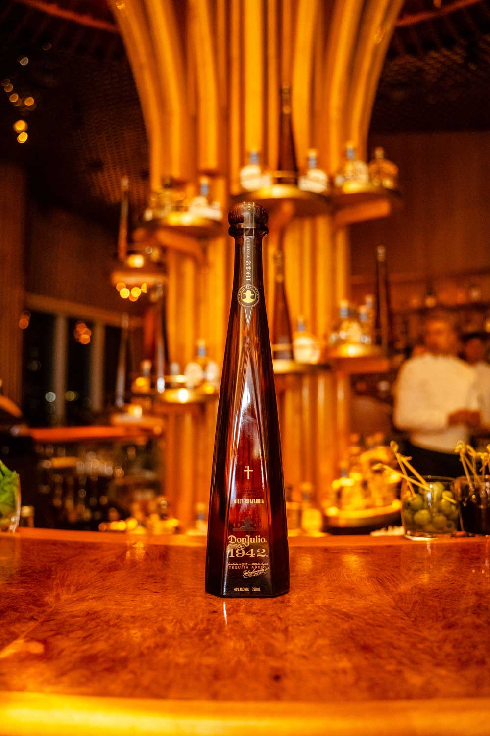 Don Julio 1942 bottle on a bar. Brought to you by Plural, NYC: Experts in Social Media Marketing Strategy and High-Quality Content Production.