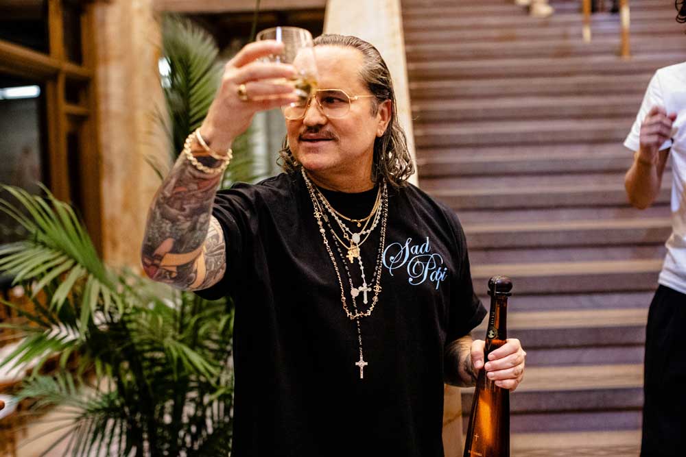 A man holds up a glass liquor in a toast holding a bottle of Don Julio 1942 in his other hand. Image by Plural, NYC - Social Media Marketing & Content.